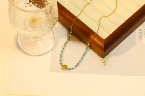 Goldene Halskette mit Baumanhänger und blauem Naturstein